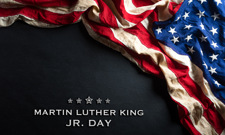 Martin Luther King Day anniversary concept. American flag against black wooden background